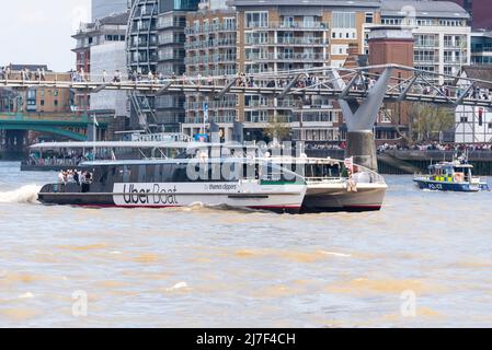 Uber Boat, Thames Clippers, nommé venus Clipper, passant sous le pont du millénaire avec des personnes traversant la Tamise. Lancement de la police Banque D'Images