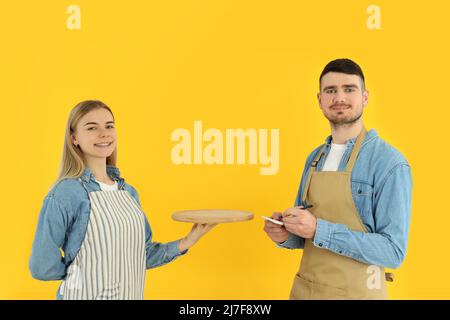 Concept d'occupation, jeunes serveurs sur fond jaune Banque D'Images