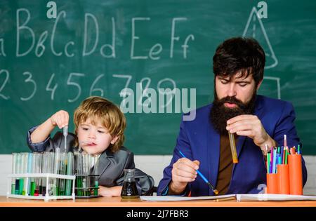 Jouez avec des liquides. Professeur et laboratoire de chimie de garçon. Étudier la chimie et la biologie. Exemple personnel inspirant. Connaissances scolaires. Journée des connaissances Banque D'Images