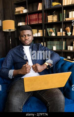 Jeune homme indépendant afro-américain travaillant avec des collègues sur la vidéo réunion, à l'aide d'un ordinateur portable. Homme d'affaires élégant et amical ayant une réunion vidéo Banque D'Images