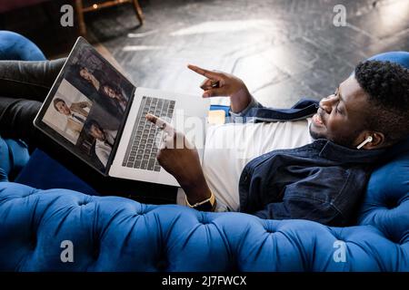 Homme noir indépendant réussi parlant sur conférence appel vidéo à des collègues en ligne. Un étudiant afro-américain parle à un professeur et à d'autres étudiants Banque D'Images