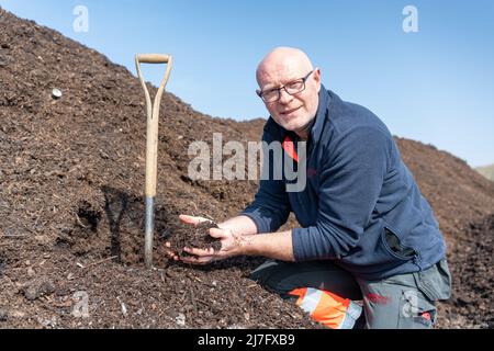 Un agriculteur inspecte une pile de fumier de cour de ferme qui a été compostée, pour aider à prévenir le lessivage de l'azote du sol. North Yorkshire, Royaume-Uni. Banque D'Images