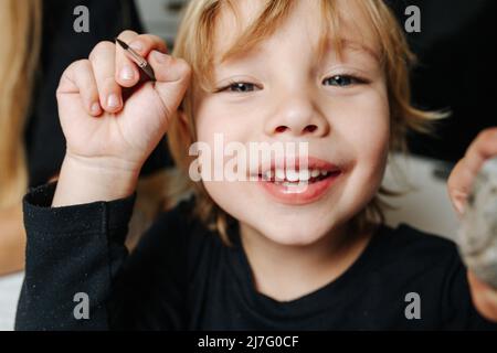 Portrait d'un joli petit garçon à tête juste avec une brosse dans la main. Gros plan. Banque D'Images