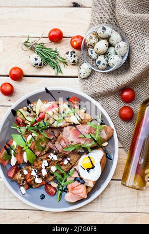 Beaucoup de délicieux bruschetta avec fromage, tomate, oeuf de caille, jambon, saumon, légumes et herbes rôtis Banque D'Images