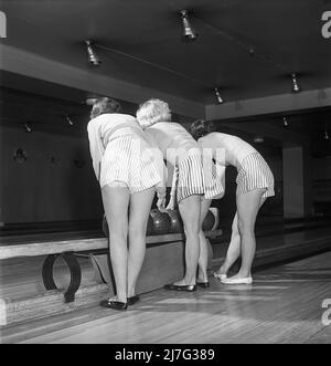 Bowling dans le 1950s. Trois filles sont bowling pour la première fois. Elles sont vêtues de jupes et de pulls à rayures courtes. Les trois filles sont toutes des actrices de théâtre : Ingrid Björk, UllaCarin Rydén et BRITA Ulfberg. 1950. Suède Kristoffersson réf. AY36-10 Banque D'Images