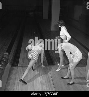 Bowling dans le 1950s. Trois filles sont bowling pour la première fois. Elles sont vêtues de jupes et de pulls à rayures courtes. Les trois filles sont toutes des actrices de théâtre : Ingrid Björk, UllaCarin Rydén et BRITA Ulfberg. 1950. Suède Kristoffersson réf. AY36-9 Banque D'Images