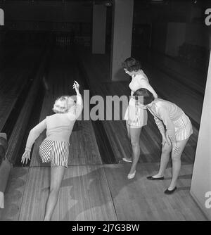 Bowling dans le 1950s. Trois filles sont bowling pour la première fois. Elles sont vêtues de jupes et de pulls à rayures courtes. Les trois filles sont toutes des actrices de théâtre : Ingrid Björk, UllaCarin Rydén et BRITA Ulfberg. 1950. Suède Kristoffersson réf. AY36-12 Banque D'Images