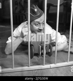 Père en 1940s. L'acteur Åke Söderblom, 1910-1965 ans, essaie de son mieux d'amuser son fils de l'extérieur du parc à jouer avec un canon miniature. Suède 1949 AN93-1 Banque D'Images