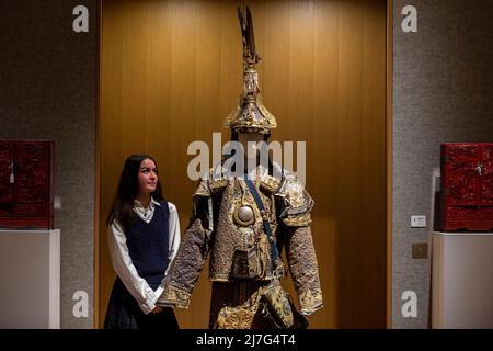 Londres, Royaume-Uni. 9 mai 2022. Un membre du personnel pose avec “Un costume rare d'armure de cérémonie avec Helmet et quiver”, fin de la dynastie Qing, (est. £10 000 - £15 000) à un aperçu de la vente des Beaux-Arts chinois de Bonhams à leur galerie New Bond Street. Des jades chinoises, des céramiques, des laques, des textiles impériaux et des objets d'art seront mis en vente le 12 mai. Credit: Stephen Chung / Alamy Live News Banque D'Images