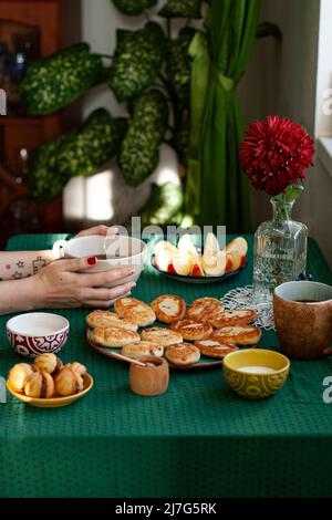 Petit déjeuner pour deux : fromages avec raisins secs de fromage maison, crème sure, café noir, pomme et noix avec lait condensé. Sur la table se trouve un transparent Banque D'Images