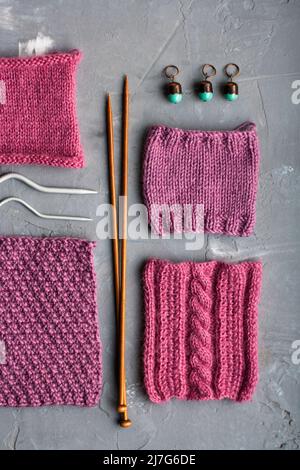 Vue de dessus: Les accessoires de tricotage et les échantillons de produits tricotés se trouvent sur un fond en béton gris. Lieu d'inscription. Banque D'Images