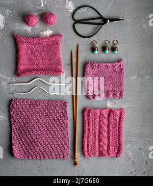 Vue de dessus: Les accessoires de tricotage et les échantillons de produits tricotés se trouvent sur un fond en béton gris. Lieu d'inscription. Banque D'Images