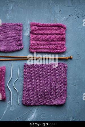 Vue de dessus: Les accessoires de tricotage et les échantillons de produits tricotés se trouvent sur un fond en béton gris. Lieu d'inscription. Banque D'Images