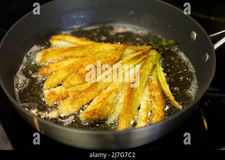 Aubergine frite dans une casserole dans de l'huile bouillante. Banque D'Images