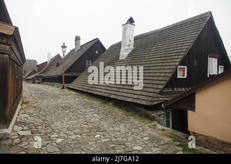 Maisons traditionnelles en bois (roubenka) et rue pavée de la ville pittoresque de Štramberk, dans la région morave-Silésie de la République tchèque. Banque D'Images