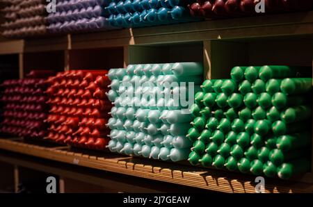 Bougies bâton colorées disposées sur des étagères et triées par couleur dans un magasin de bougies. Banque D'Images