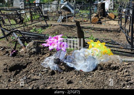 Fleurs sur fond de monuments détruits dans le cimetière pendant la guerre Russie-Ukraine. Des tirs russes d'Odessa, des roquettes ont frappé le cimetière de Novo-Gorodskoe (ou le cimetière de Tairovsky). Détruit plus de 1000 mètres carrés du cimetière. Banque D'Images