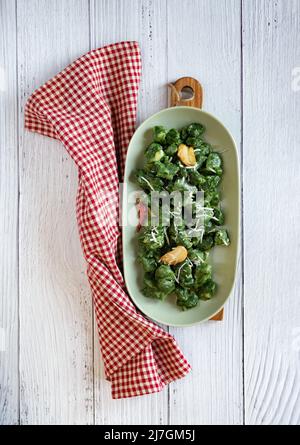 gnocchi vert à base d'épinards, de pommes de terre et de farine assaisonnée d'huile d'olive et de parmesan Banque D'Images