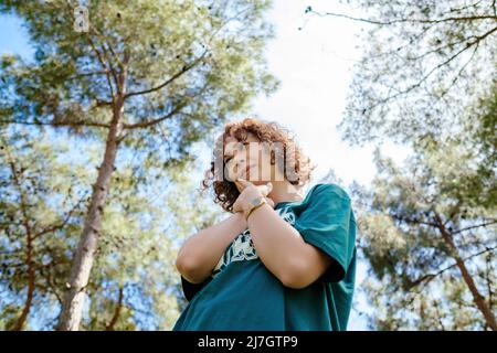 Jeune femme à tête rouge portant un t-shirt vert touchant la bouche avec ses mains avec une expression douloureuse en raison de maux de dents ou de maladies dentaires sur les dents. Co. Santé Banque D'Images