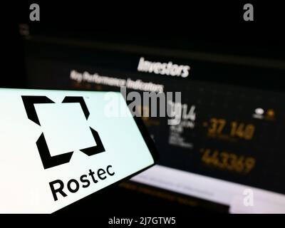 Smartphone avec le logo de la société russe de défense Rostec sur l'écran en face du site Web d'affaires. Mise au point au centre-gauche de l'écran du téléphone. Banque D'Images