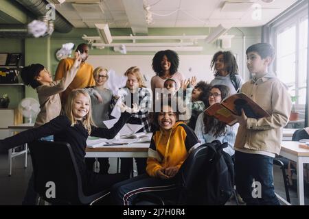 Groupe joyeux d'élèves avec des enseignants en classe à l'école Banque D'Images