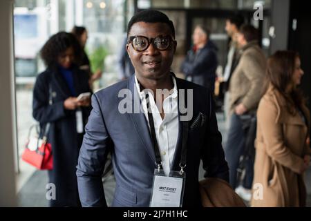 Homme d'affaires portant une carte d'identité dans le hall du centre de conférence Banque D'Images