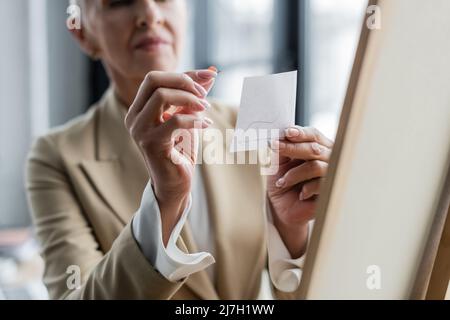 mise au point sélective d'une note en papier et d'une punaise dans les mains d'un banquier rogné sur un arrière-plan flou Banque D'Images