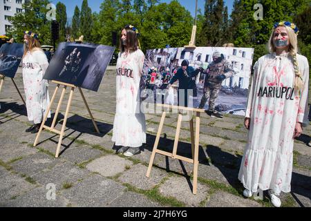 Des militants peints en rouge symbolisant les victimes civiles de la guerre sont vus sur la manifestation. Des centaines d'Ukrainiens et d'activistes polonais ont protesté dans un cimetière de Varsovie auprès des soldats de l'Armée rouge morts pendant la Seconde Guerre mondiale L'ambassadeur de Russie en Pologne, Sergey Andreev, a été frappé de peinture rouge par des manifestants opposés à la guerre en Ukraine lors d'un événement annuel du jour de la victoire commémorant la fin de la Seconde Guerre mondiale L'Ambassadeur Sergey Andreev est arrivé au cimetière des soldats soviétiques pour y déposer des fleurs le jour de la victoire, mais le diplomate et sa délégation ont été forcés de quitter la zone, accompagnés de la police Banque D'Images