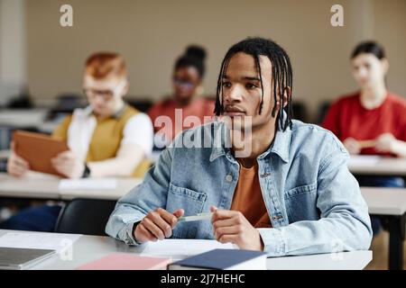 Portrait d'adolescent noir avec des tresses écoutant la conférence à l'école ou à l'université, espace de copie Banque D'Images