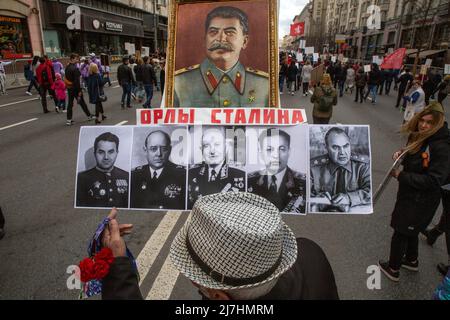 Moscou, Russie. 9th mai 2022. Un homme tient des portraits de Joseph Staline et de célèbres chefs militaires de l'armée soviétique de la Seconde Guerre mondiale lors de la marche du Régiment d'immortels marquant le 77th anniversaire de la victoire de la Seconde Guerre mondiale, à Moscou, en Russie. La bannière indique « les aigles de Talin ». Nikolay Vinokurov/Alay Live News Banque D'Images