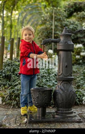 Garçon lave sa main sous le robinet dans le parc, concept d'hygiène Banque D'Images
