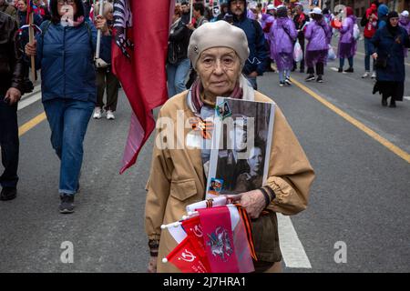 Moscou, Russie. 9th mai 2022. Une femme tient un portrait de ses proches (soldat de la Seconde Guerre mondiale), alors qu'elle participe à la marche du régiment d'Immortal à la rue Tverskaya à Moscou, en Russie. Cet événement célèbre la défaite de l'Allemagne nazie par l'Union soviétique au cours de la Seconde Guerre mondiale Banque D'Images