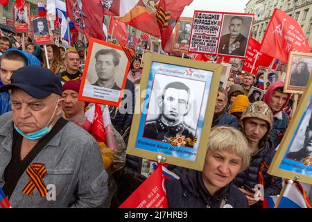 Moscou, Russie. 9th mai 2022. Les personnes qui ont tenu des photos de leurs proches qui ont combattu l'Allemagne nazie pendant la Seconde Guerre mondiale assistent à la marche du régiment d'Immortal marquant le 77th anniversaire de la victoire de la Seconde Guerre mondiale, dans le centre de Moscou, en Russie Banque D'Images