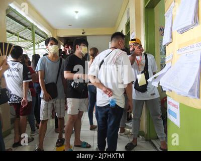 Caloocan, Philippines. 09th mai 2022. Un officier du COMELEC a vu guider les électeurs dans quelle salle ils sont désignés. 65,7 millions de Philippins se rassemblent dans leurs préceptes respectifs pour exercer leur droit de vote. Ils voteront pour décider qui sera le prochain président. Et ils rempliront également leurs bulletins de vote pour des postes exécutifs et législatifs aux niveaux national, provincial et local. Crédit : SOPA Images Limited/Alamy Live News Banque D'Images