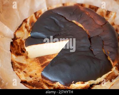 Gâteau au fromage basque brûlé avec une surface extérieure riche et sombre caramélisée et un foyer sélectif jiggly moyen Banque D'Images