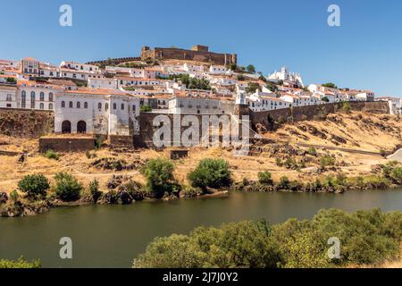 Vue sur le village de Mértola au Portugal, avec le fleuve Guadiana en premier plan, par une journée ensoleillée en été. Banque D'Images
