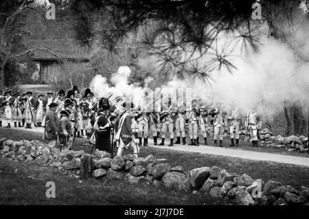 Reconstitution des Redcoats tirant leurs fusils à Minutemen pendant la simulation d'attaque des Redcoats sur Battle Road à Lexington sur Patriots Weeken Banque D'Images