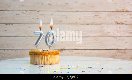 Joyeux anniversaire chiffres argentés sur les tableaux blancs arrière-plan de l'espace de copie. Belle carte d'anniversaire avec un cupcake et une bougie Banque D'Images