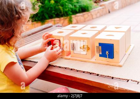 Boîtes en bois avec serrures, matériel éducatif montessori pour manipuler des objets par des enfants avec dextérité. Banque D'Images