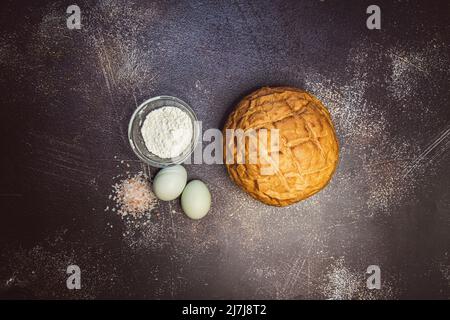 Pain au levain rond avec œufs bleus, sel rose et farine. Banque D'Images