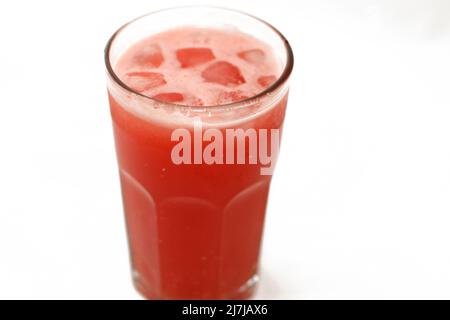 Un verre de jus de smoothie frais de pastèque, foyer sélectif de smoothies de melon froid boire dans un verre avec des cubes de glace isolés sur un backgrou blanc Banque D'Images