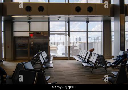 Vider les sièges de l'aéroport dans le terminal d'attente avec un avion stationné à l'extérieur. Banque D'Images