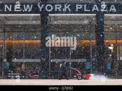 NEW YORK, New York – le 7 février 2021 : un homme d'équipage travaille devant un immeuble de bureaux à Lower Manhattan pendant une tempête d'hiver. Banque D'Images