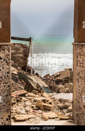 Maison de pêcheur détruite par une tempête sur les rives de la mer Méditerranée en Andalousie, Espagne. Vue à travers une clôture. Banque D'Images