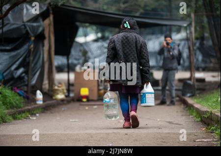 Bogota, Colombie le 9 mai 2022. Une femme indigène transporte de l'eau alors que les communautés autochtones d'Embera commencent à quitter le camp de fortune monté il y a 8 mois où plus de 1000 000 autochtones déplacés par un conflit vivaient et ont conclu des accords avec le gouvernement pour être transférés à un endroit voisin avant de retourner sur leur territoire, à Bogota, Colombie le 9 mai 2022. Photo de: CHEPA Beltran/long Visual Press Banque D'Images