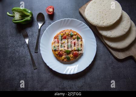 Pizza italienne très prisée dans une assiette blanche sur fond. Gros plan, mise au point sélective. Banque D'Images