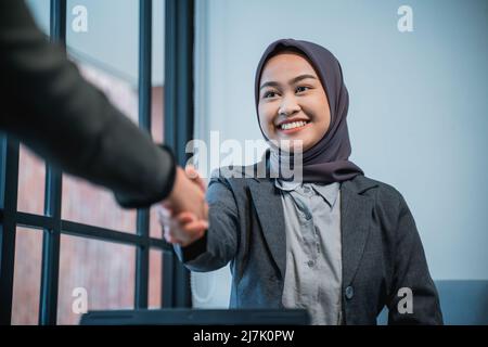 femme qui se secoue la main tout en faisant une pause au bureau Banque D'Images