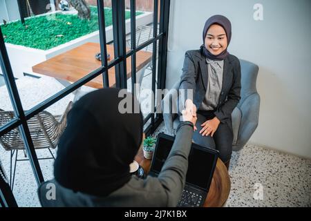 femme qui se secoue la main tout en faisant une pause au bureau Banque D'Images