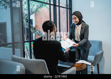 muslim Woman Business donner une proposition à son partenaire Banque D'Images