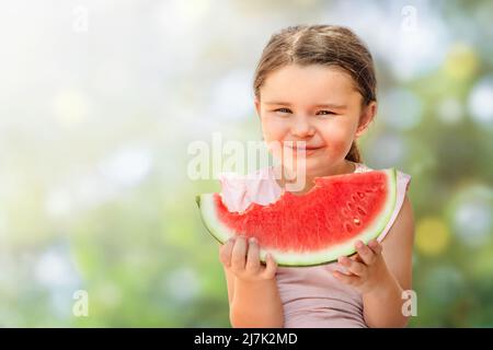 Fille heureuse avec morsure de pastèque isolée sur fond blanc Banque D'Images